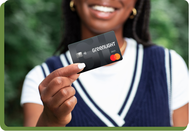 Girl holding Greenlight Debit Card
